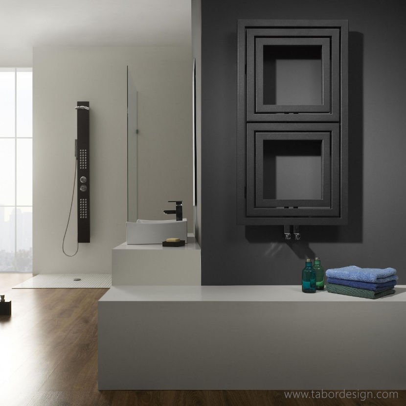 Grzejniki dekoracyjne premium. Prostokątny pionowy grzejnik we wnętrzu nowoczesnej łazienki. Prysznic i umywalka w tle.