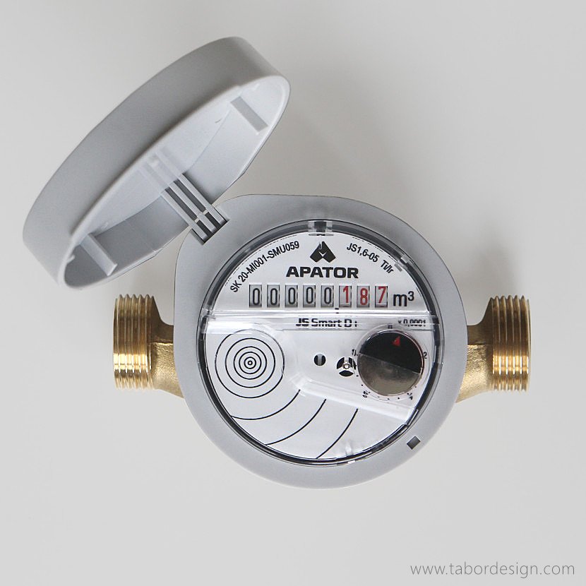 Tarcza mechanizmu zliczającego Wodomierza Apator widziana z góry. Klapka odchylona. Widoczne gwinty przyłączy.